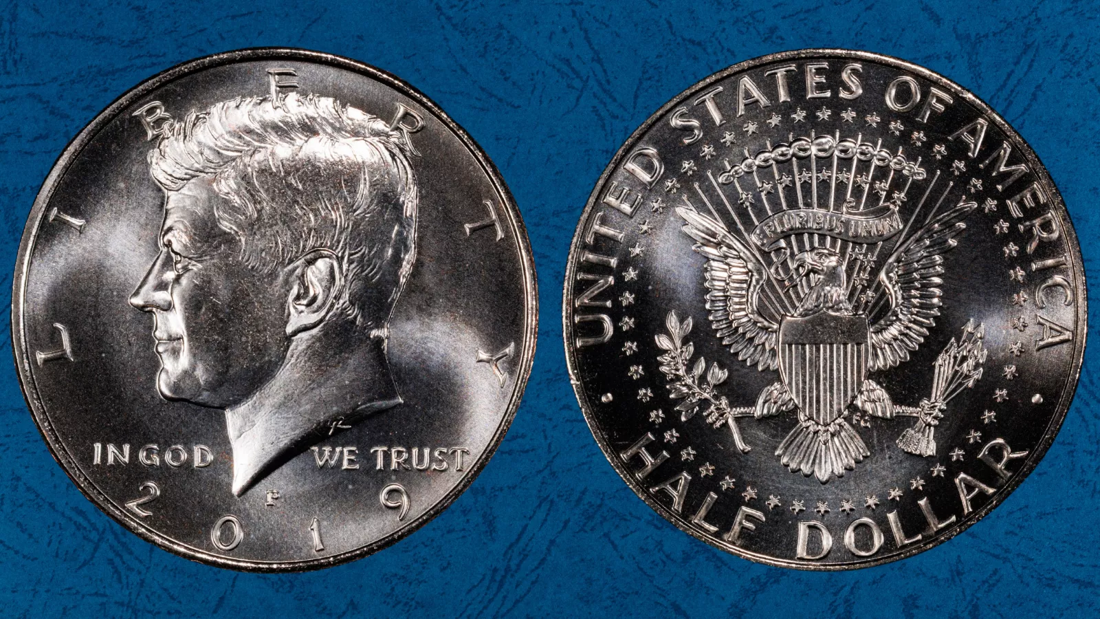 Grading strip showing four 2019 Kennedy half dollars from worn to gem quality illustrating how condition affects value